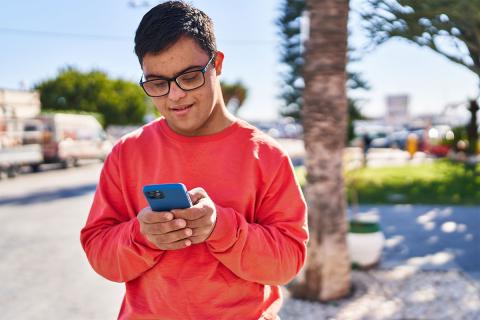 Young man looking at phone outside
