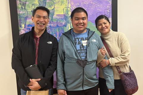 Caregivers with young man standing and smiling