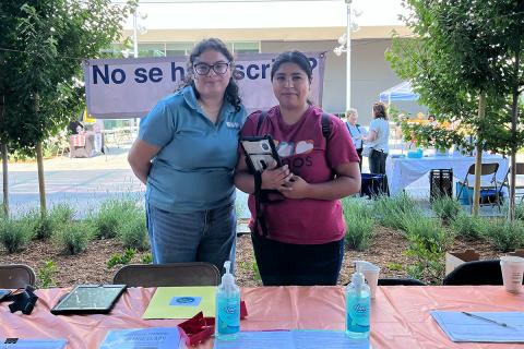 Two Manos employees at a booth outside